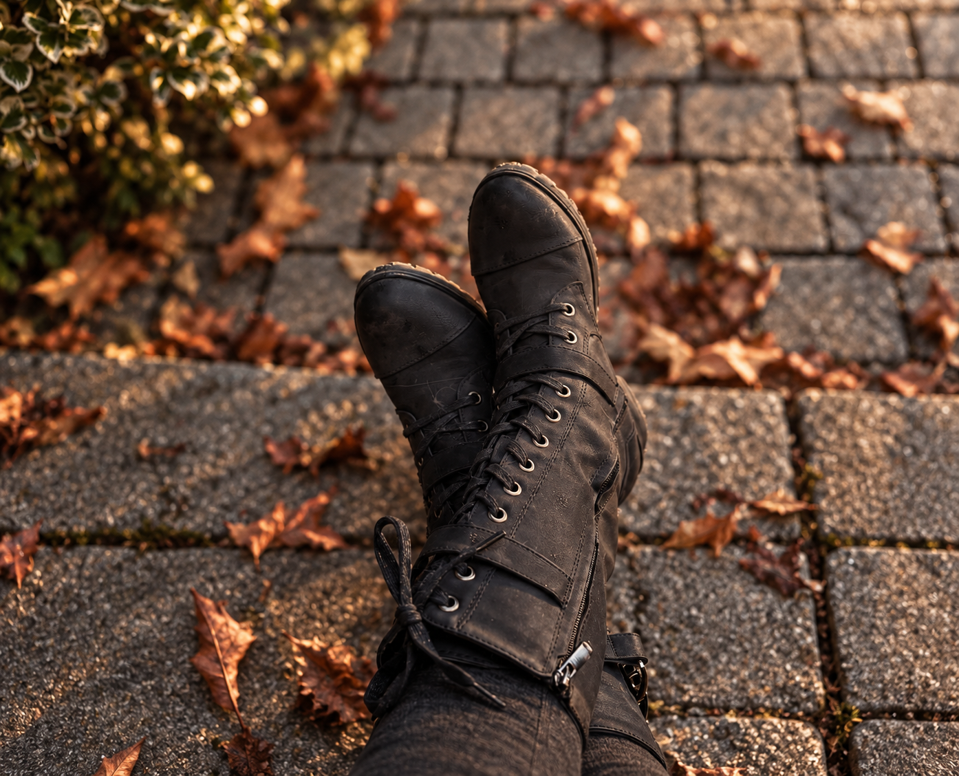 Witchy boots on a cobblestone path with autumn leaves.