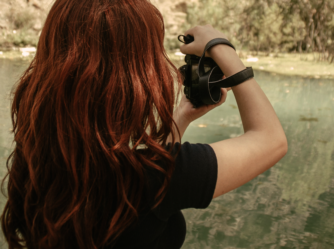 Redhead with wavy hair at a rocky beach.